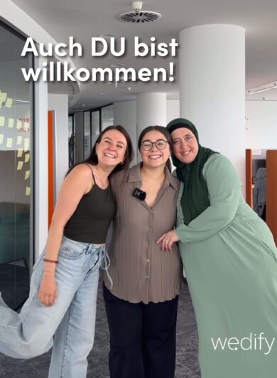Drei Frauen stehen im Bild und umarmen sich, sie lachen in die Kamera und es steht