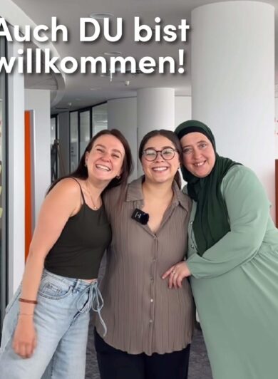 Drei Frauen stehen im Bild und umarmen sich, sie lachen in die Kamera und es steht 