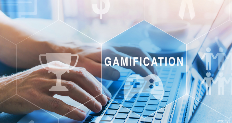 Ein Symbolbild für Gamification: eine Hand auf einem Laptop und Symbole für Gaming und Erfolg