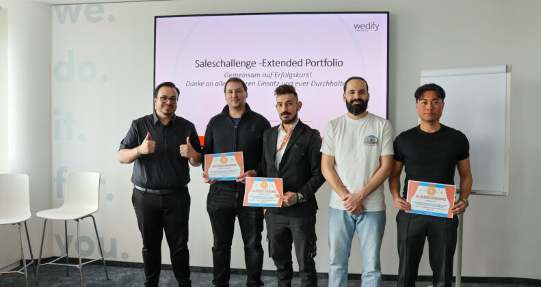 5 Mitarbeiter auf einem Gruppenfoto, mit Zertifikaten und Daumen hoch
